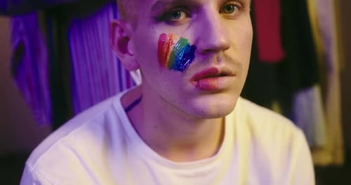 Portrait of LGBT Individual with Pride Flag on Cheek