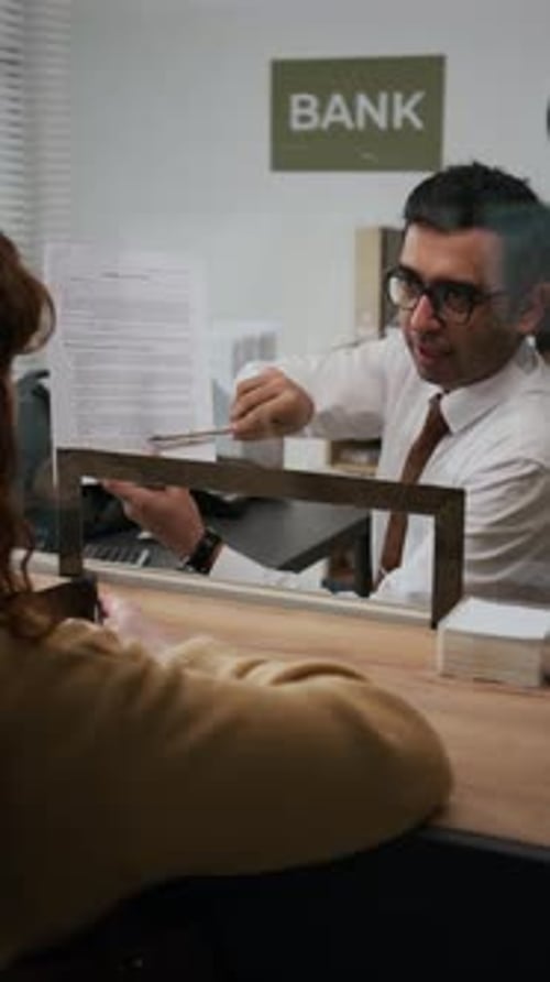 Unrecognizable Red-Haired Woman Listening to Bank Employee in Office