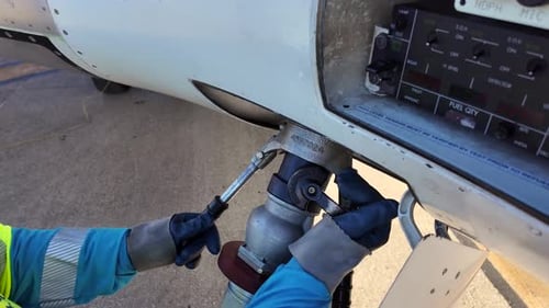 Fuel Truck Operator Disconnecting the Fuel Hose From a Medium Size Jet Airplane on the Apron