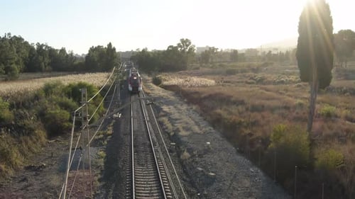 Train Travels Through Rural Landscape on Sunny Day
