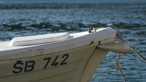 Boot vor Anker im Hafen am Meer, Nahaufnahme eines am Boot befestigten Seilankers
