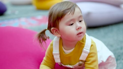 Cute 3-Year-Old Toddler Girl Looking At Something In A Play Area Inside A Shopping Mall. - Closeup