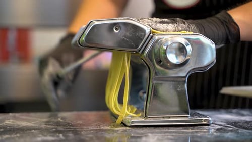 Close up passing the dough into the machine that cuts it, italian tradition 4K