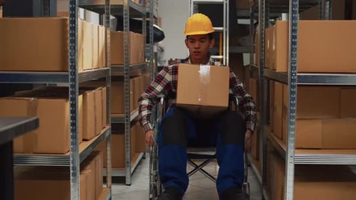Male Worker with Impairment Taking Boxes Off of Shelves