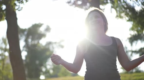 Woman Celebrates Marathon Victory in Sunny Park