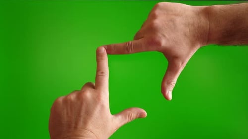 09 Pz. Human hands show a gesture forming a frame on a green background.