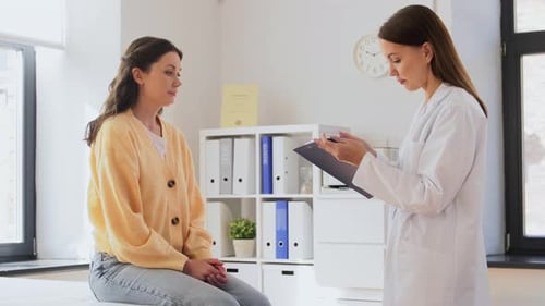 Woman patient talks with doctor in white office