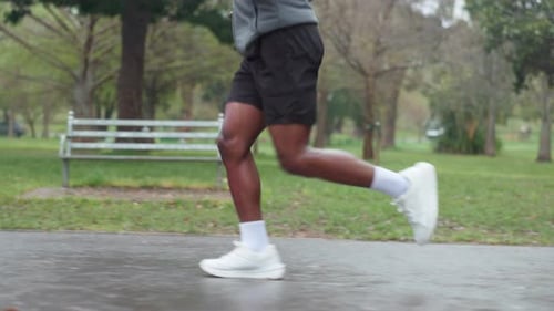 Running, fitness and legs of man in park for exercise, marathon training and cardio workout