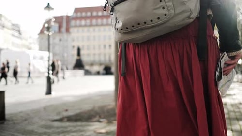 Woman Exploring City With Map and Backpack