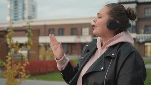 Joyful Lady Dances in Urban Outdoor Setting on Cool Breezy Day