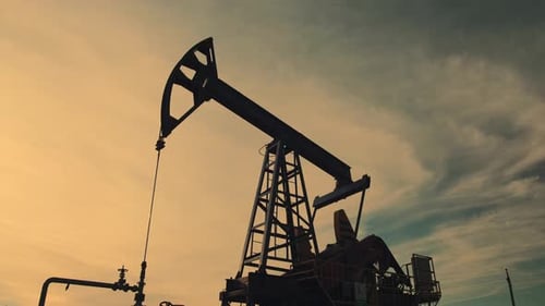 Silhouetted Oil Pump Jack Against Dusky Sky