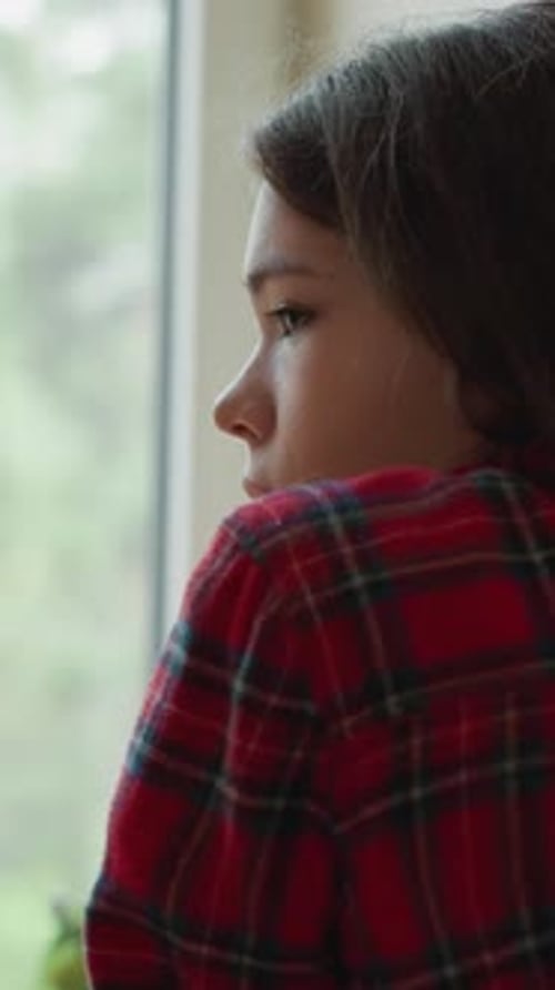 Young Girl Looking Out Bright Window