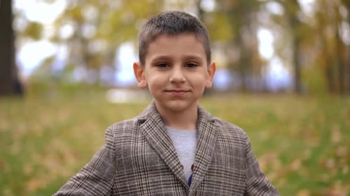 Cute Boy Smiling and Blowing a Kiss Outdoors