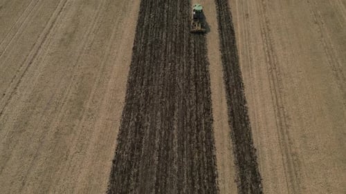 Tractor Plowing Field In Summer - Aerial Drone Shot