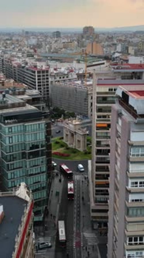 Vista aérea de drone de carros se movendo nas ruas entre os edifícios, perto de Porta De La Mar em Valen