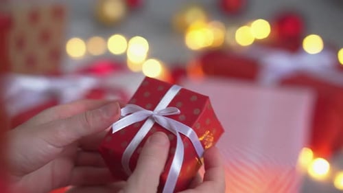 Person Untying Gift Ribbon Close Up at Christmas