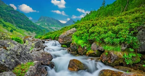 Zeitrafferlandschaft eines sich bewegenden Gebirgsflusses und Wolken