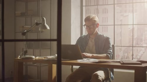Man Working at Desk on Laptop in Office