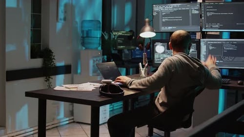 Programmer Relaxing at Desk in Office at Night