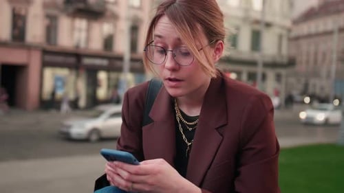 Young Adult Uses Phone in Bustling City