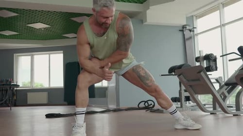Muscular Man Doing Warmup Exercises in the Gym