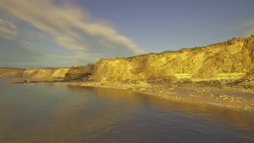 Serene Coastal Cliffs and Beach at Sunset
