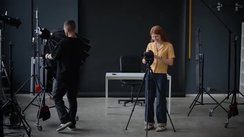 Man and Woman Preparing for Video Record, Setting Up Camera and Lights