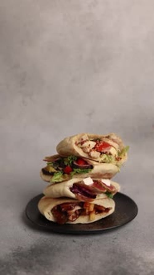 pitas with different fillings on a black plate in a restaurant