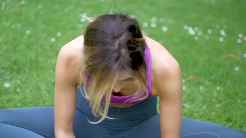 Close up view of woman stretching and doing yoga on a mat while focused on her breathing and exercis