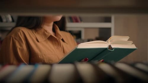Unrecognizable Woman Reading Book in University Library Near Bookcase Smart Female Girl College