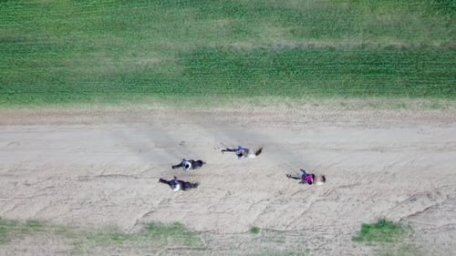 Horseback riding in a green Badlands terrain, aerial footage