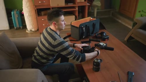 Young Man Assembling Camera in Home Workspace