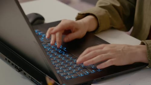 Young woman focused on typing at her laptop in a home office setting
