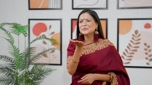 Woman in Sari Blows Kiss in Indoor Setting