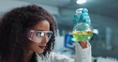 Scientist Holding Flask with Green Liquid in Lab