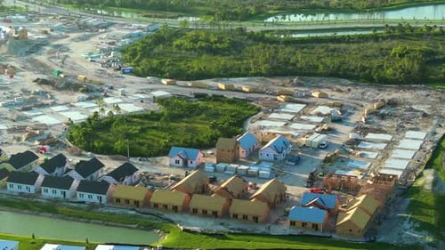View From Above of Unfinished Frames of Inexpensive Homes with Wooden Roof Beams Under Construction