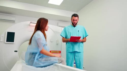 A radiologist consults a girl patient before undergoing diagnostics using an MRI machine in center