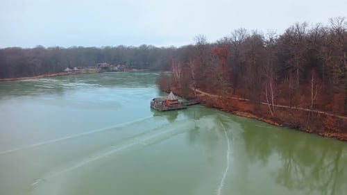 Aerial: frozen Verchat pond, wooden house and Cabanes des Grands Reflets during the day
