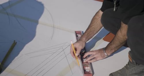 Un ouvrier de chantier de construction utilisant des niveaux pour la mise à l'échelle sur papier
