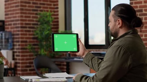 Office Worker Analyzing Horizontal Greenscreen on Tablet