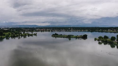 Drone shot over a glassy smooth Sloan's Lake with Penny Island sitting in the middle of the calm wat