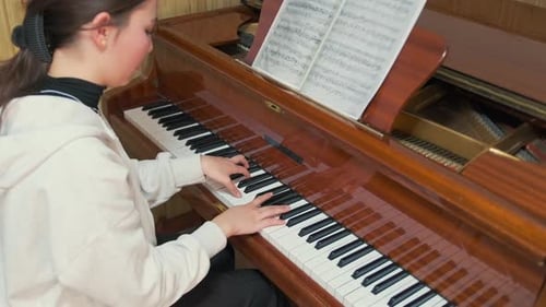 Teen Girl Plays Piano at Home, Practicing Music