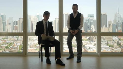 Young Men Discuss Business Overlooking a City Skyline