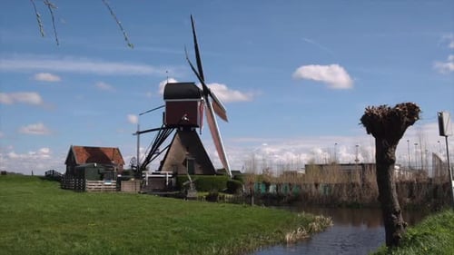 Dutch windmill turns with timeless grace, wooden blades, broad and weathered