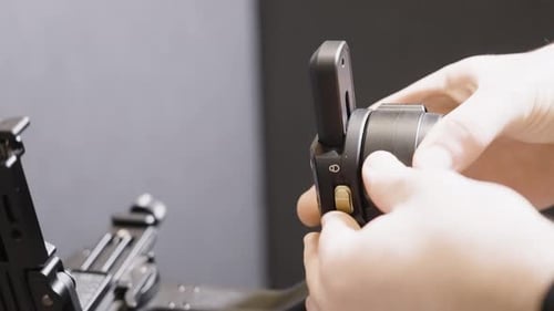 Hands Adjusting Black Metallic Camera Gimbal