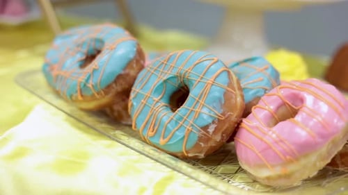 Pan table of glazed donuts that are pink, and blue.
