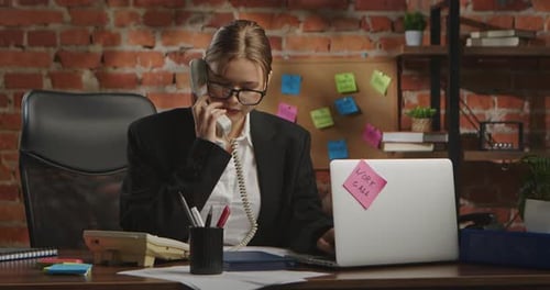 Young Businesswoman in Office with Brick Wall Background