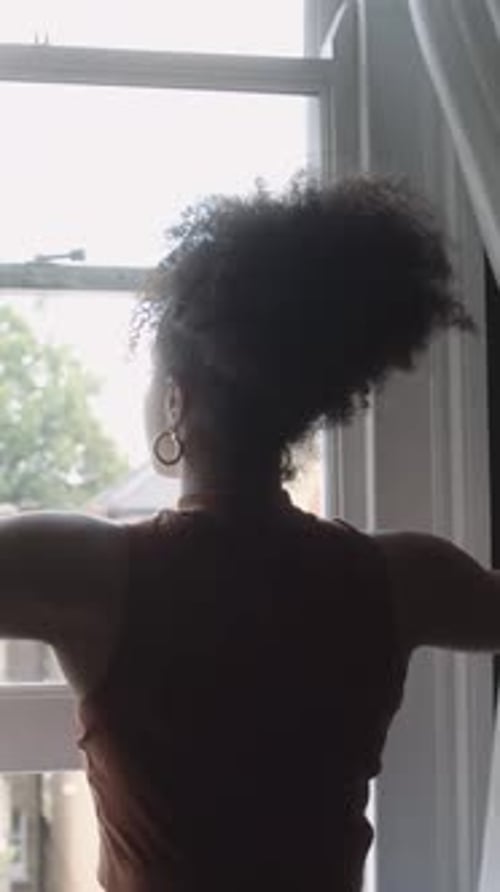 Woman Opens Window Curtains in Home Interior