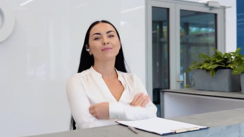 Smiling Woman at Reception Desk in Modern Office