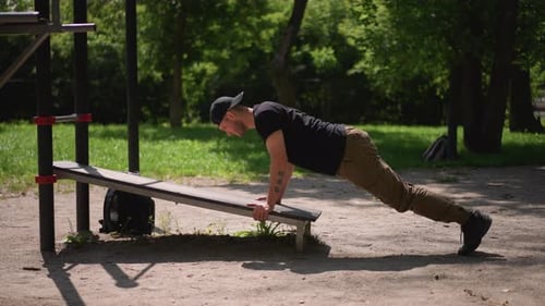 Public Park Strength Training Man In Khaki Pants Doing Press On Public Bench Summer Park Workout